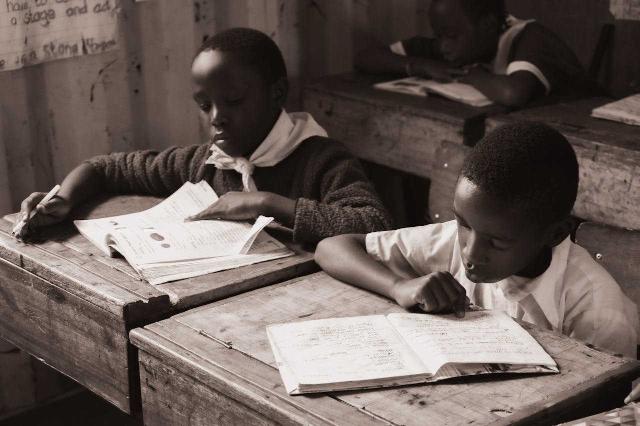 services-img-01 Black boys engrossed in reading at school, capturing the essence of education.